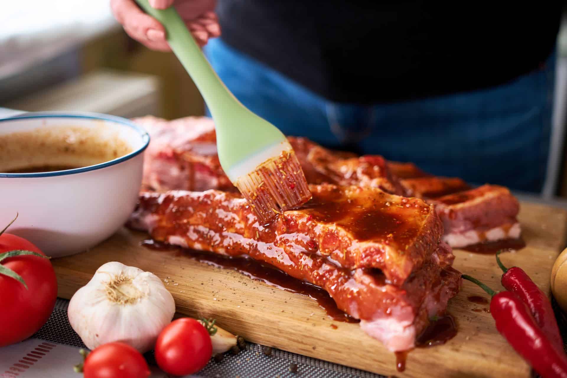 Marinade wird mit Pinsel auf Grillgut aufgetragen
