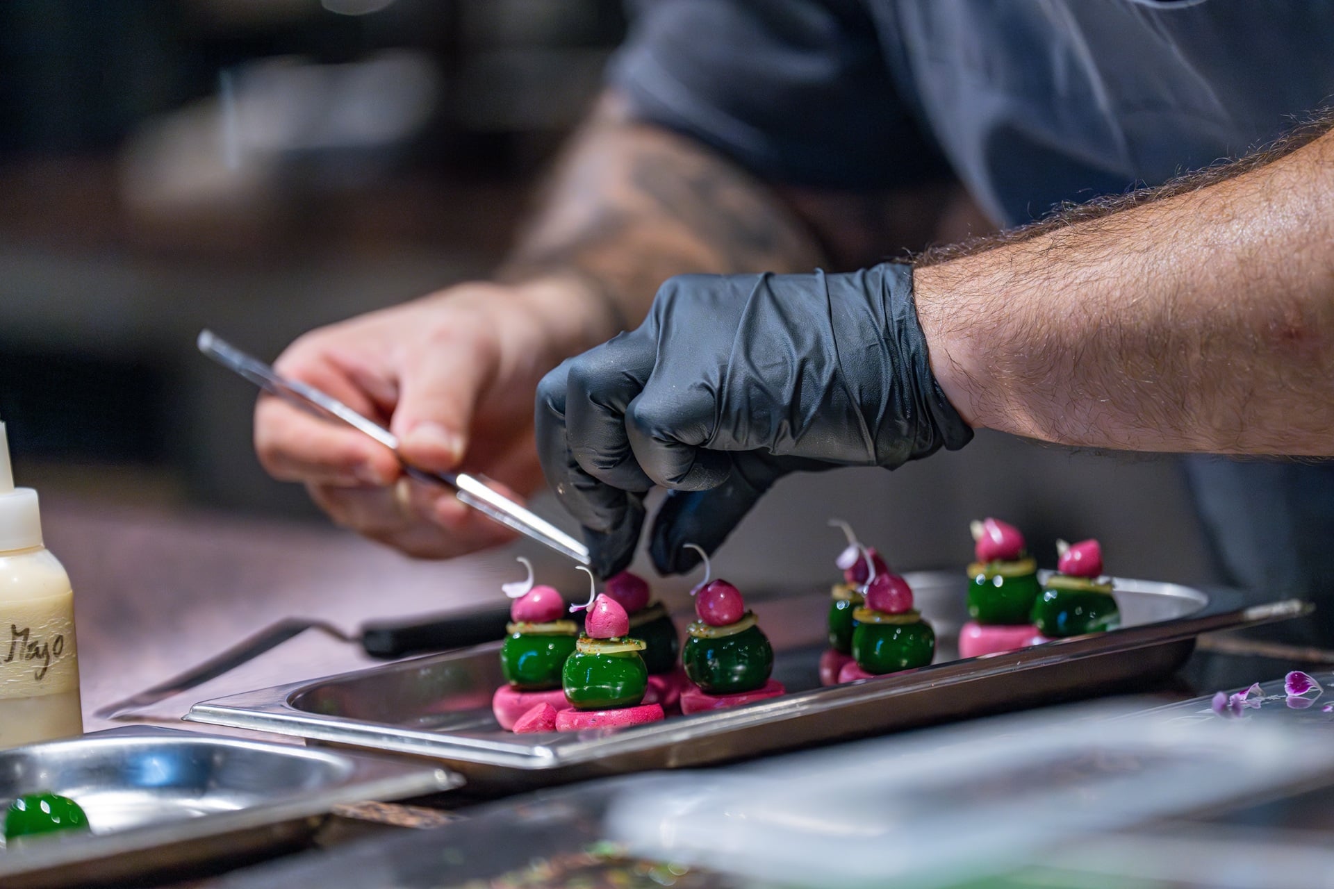 Koch dekoriert kunstvoll ein feines Gourmetgericht mit Pinzette | Weingut Bassermann Jordan